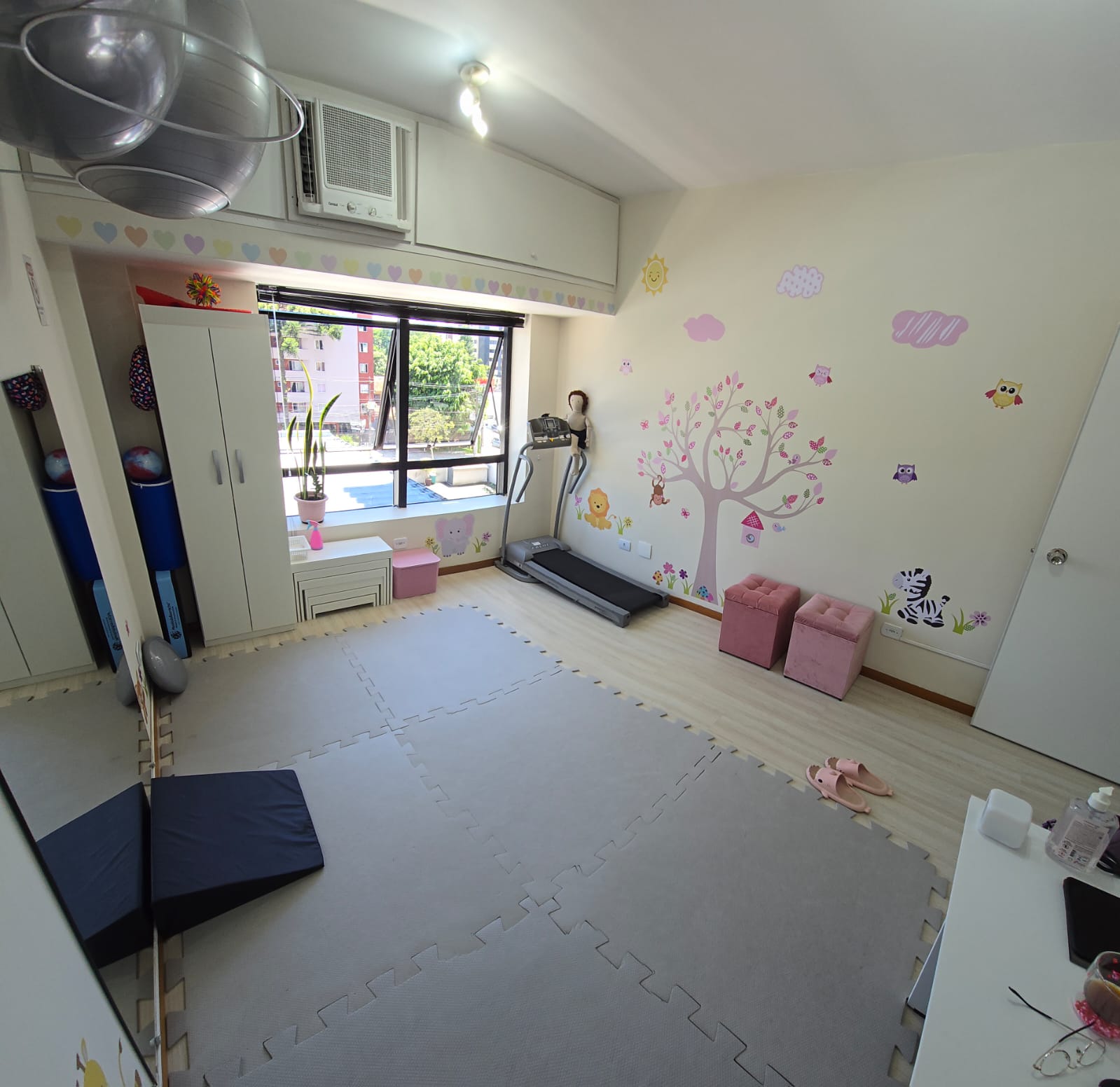 Sala de atendimento do Neuro Acolher com tatame, espelho e materiais de fisioterapia